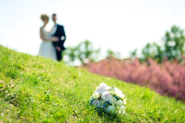美丽的婚礼新娘花束与一对夫妇的背景特写 — 图库照片