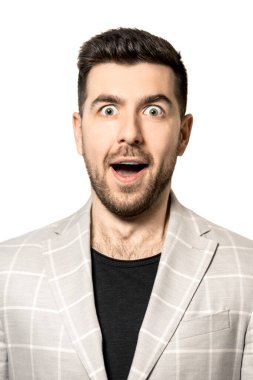 Beyaz ceketli, sakallı, beyaz arka planda şaşırmış bir yüzü olan genç bir adam..