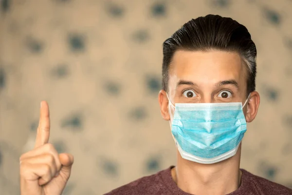 Koronavírus Biztonság Témája Egy Fiatal Férfi Meglepett Arccal Kék Maszkban — Stock Fotó