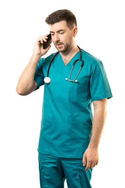 青いスーツを着た若い男性外科医が白い背景に電話で話しています — ストック写真