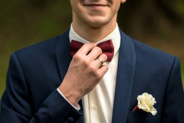 Kırmızı papyonlu mavi takım elbiseli damadın büstü..