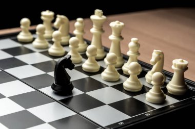 Bir satranç siyah atı rakibinin beyaz satrancının karşısında duruyor. Liderlik ve yüzleşme sembolü.