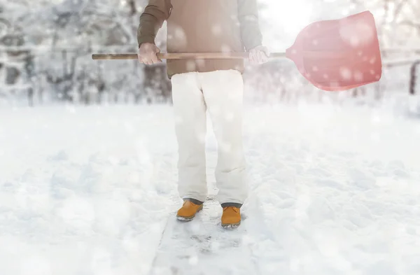 Pracovník je odstraňování sněhu na dvorku s lopatou během sněžení — Stock fotografie