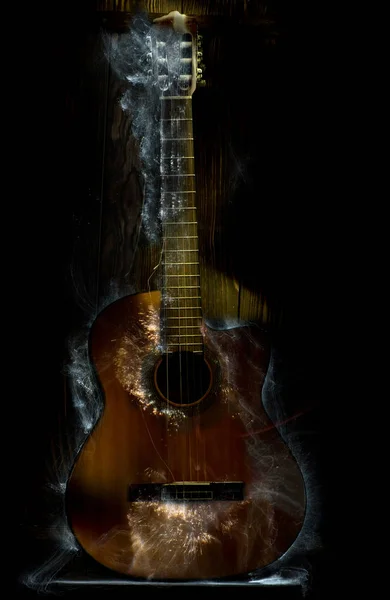 Music concept. Acoustic guitar on a dark background with rays of light