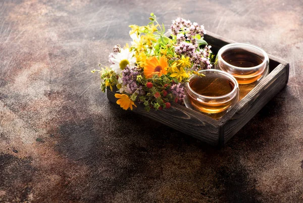 Herbs and flowers for herbal healing tea in a wooden box and cups tea