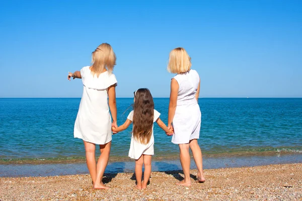 Three generations of women on the beach