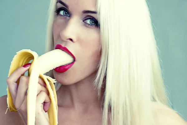 En kvinna äter en banan — Stockfoto
