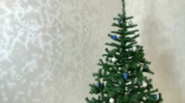 Noel ağacı, hareketli süslemeler, Noel topları, koniler, oyuncaklar, süslemeler, renkli ışıklarla parıldayan bir Noel çelengi. Noel sunumu. Hareket videosunu durdur.