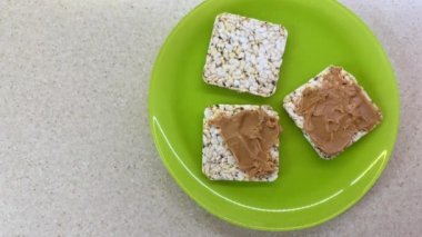 Tost, fıstık ezmesi, kuru erik, kuru üzüm ve susamlı vejetaryen sandviç yapıyorum. Sağlıklı beslenme öneriyor. Hareket animasyonunu durdur, üst görünüm.