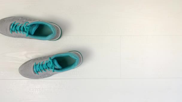 女人的蓝色运动鞋是自己穿的 一步一步地穿 停止运动 上视图 — 图库视频影像