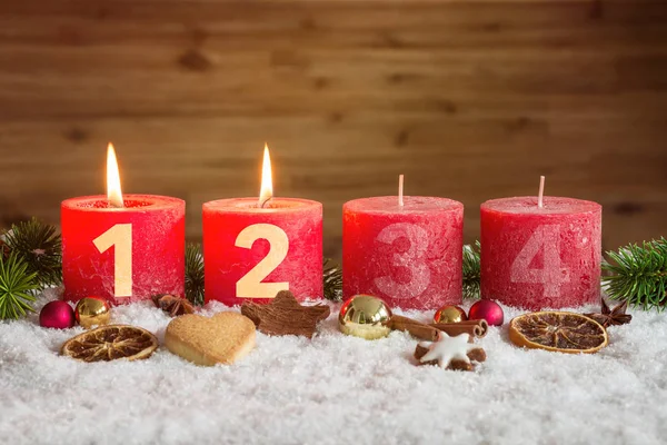 Two advent candles lit in snow