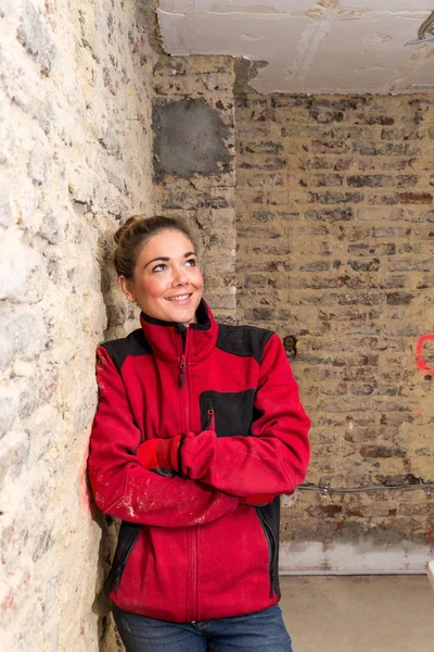Innovatieve craftswoman leunend tegen muur in kale brickw — Stockfoto