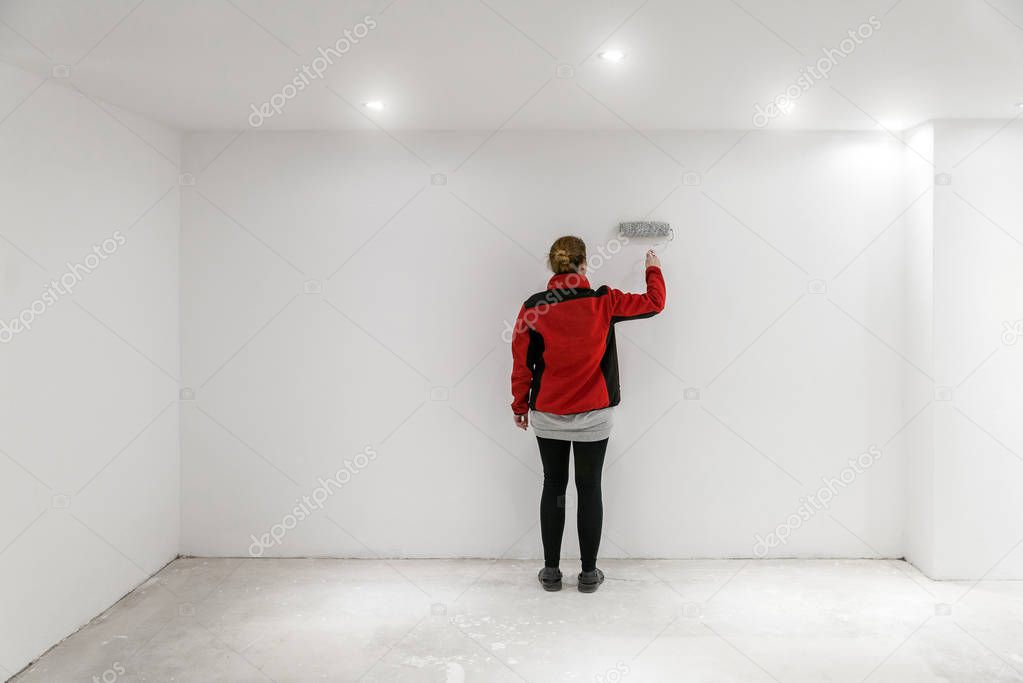 Female painter with paint roller in front of wall as template