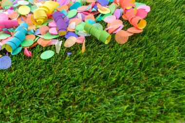 Renkli konfeti ve flamalar celebra için şablon olarak çimenlerin üzerinde