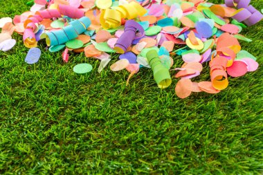 Renkli konfeti ve flamalar celebra için şablon olarak çimenlerin üzerinde