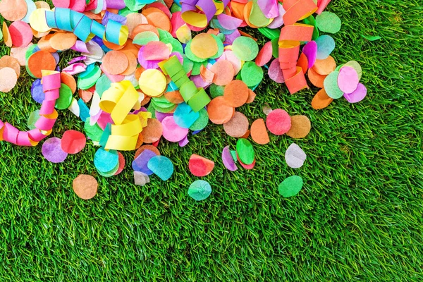 Renkli konfeti ve flamalar celebra için şablon olarak çimenlerin üzerinde