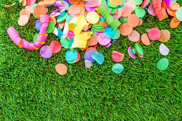 Renkli konfeti ve flamalar celebra için şablon olarak çimenlerin üzerinde