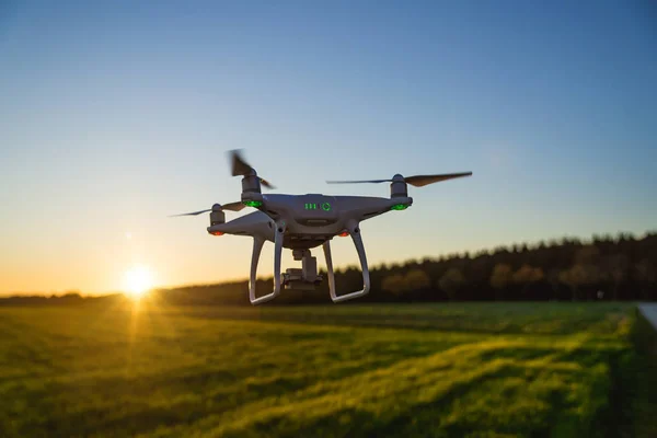 Beyaz dron kamera günbatımı sırasında uçan resim