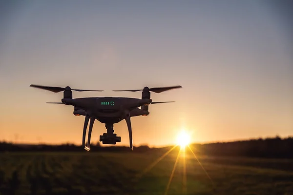 Beyaz dron kamera günbatımı sırasında uçan resim