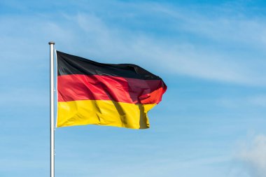 Arka planda gökyüzü ile rüzgarda salladıktan Alman bayrağı