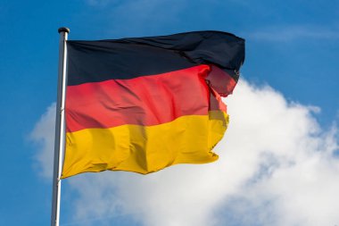 Alman bayrağı mavi gökyüzü ile rüzgarda salladıktan 