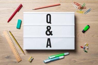 Q & A written on lightbox in office as flatlay clipart