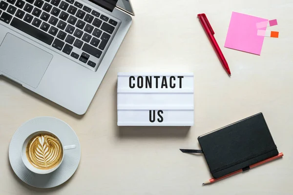Contact us written on lightbox in office as flatlay — Stock Photo, Image