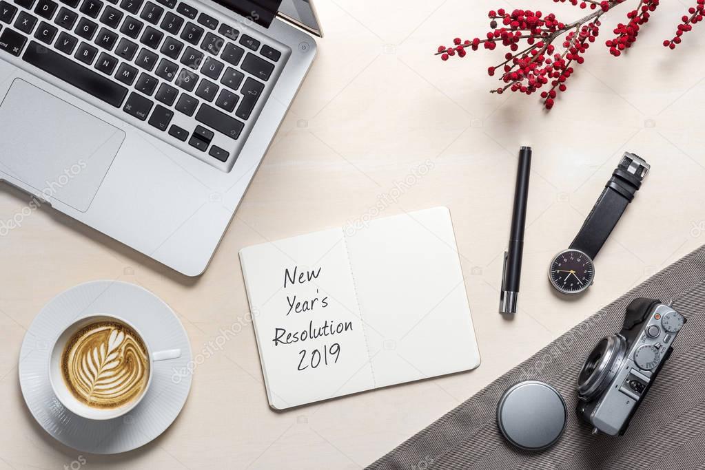 New year's resolution 2019 written on open notepad as flatlay