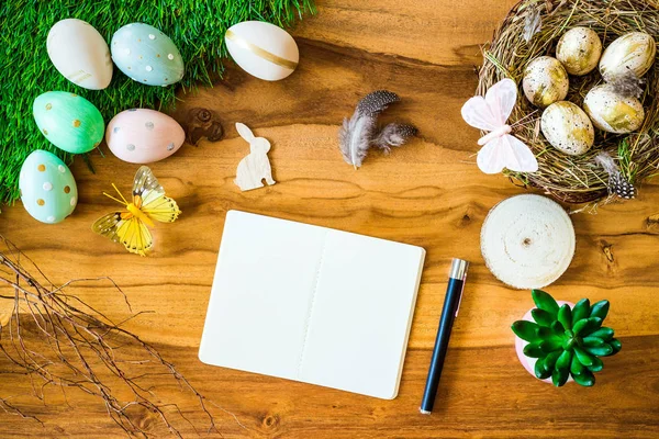 Cuaderno y pluma en blanco con espacio libre y decoraciones de Pascua fr — Foto de Stock