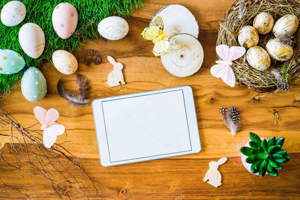 Blank tablet screen with free copyspace and easter decorations f
