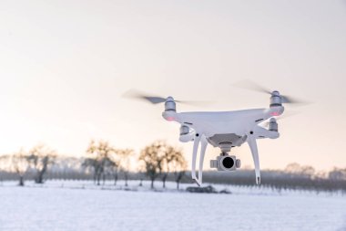 Beyaz kar ve alanı ile hava yüzen beyaz dron kamera 