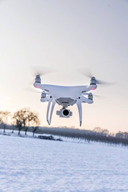 Beyaz kar ve alanı ile hava yüzen beyaz dron kamera 