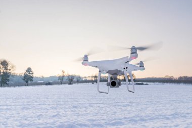 Beyaz kar ve alanı ile hava yüzen beyaz dron kamera 