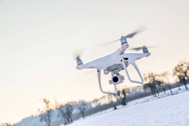 Beyaz kar ve alanı ile hava yüzen beyaz dron kamera 