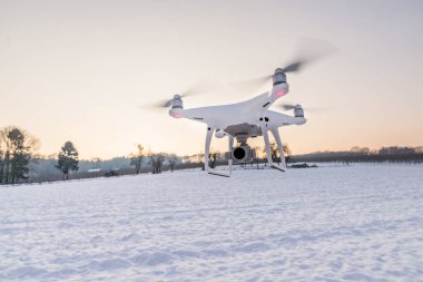 Beyaz kar ve alanı ile hava yüzen beyaz dron kamera 