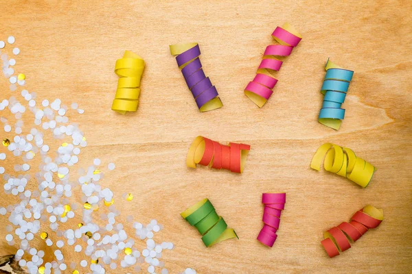 Colorido confeti y serpentín sobre fondo de madera desde arriba — Foto de Stock