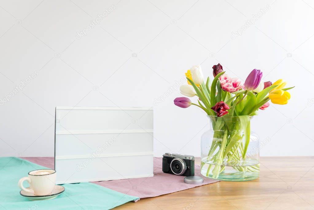 Light box with copy space and flowers on wooden desk with white 