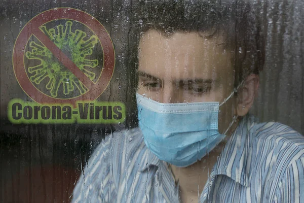 顔のマスクを身に着けている若い男 Covid 19で病気や隔離 病院の窓の外を見て コロナウイルスやCovid 19コンプからの保護 — ストック写真