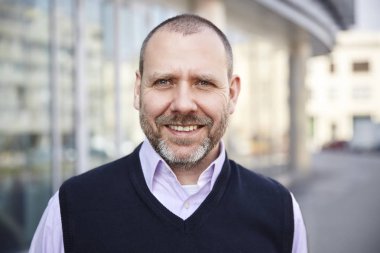 Binanın önünde gülümseyen adam