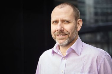 Olgun ofis çalışanı ofisinin önünde