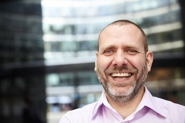 İşadamı ofisinin önünde gülüyor