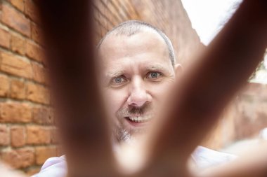 Parmaklarının arasından görünüyor