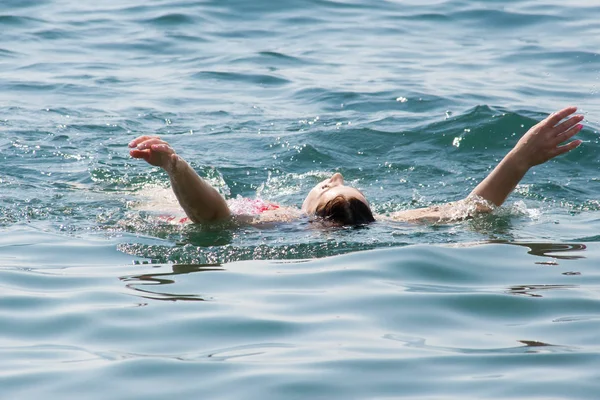 Mujer joven nadando en el océano — Foto de Stock