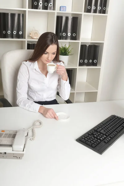 The beautiful employee has coffee in a workplace — Stock Photo, Image