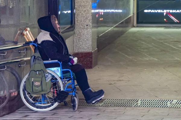 Beggar in a wheelchair asks for alms — Stock Photo, Image