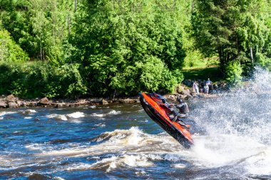 Bir adam Vuoks nehri boyunca su motosikleti sürüyor.