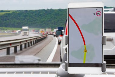 Bir yaz günü trafik sıkışıklığında arabanın ön panelinde navigasyon programı olan bir telefon.