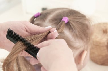 Anne elleri tarıyor. Beyaz kazaklı üç yaşındaki küçük bir kızı.