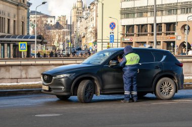 Moskova, Rusya-15 Şubat 2020: Polis memuru belgeleri şoförle kontrol ediyor. Moskova 'da sokaklarda birçok polis memuru görev başında.