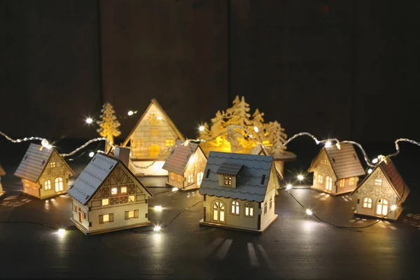 Маленькие деревянные домики со светом на столе — стоковое фото